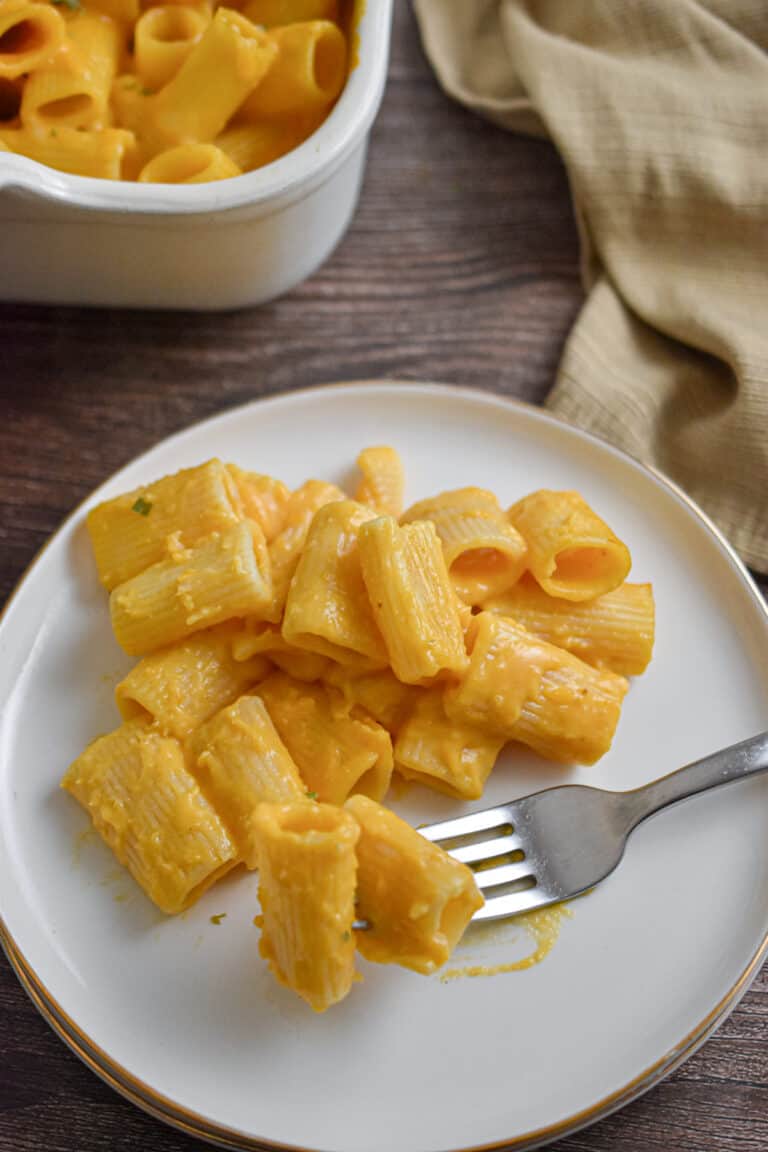 The butternut squash mac and cheese is on a plate next to the pan.