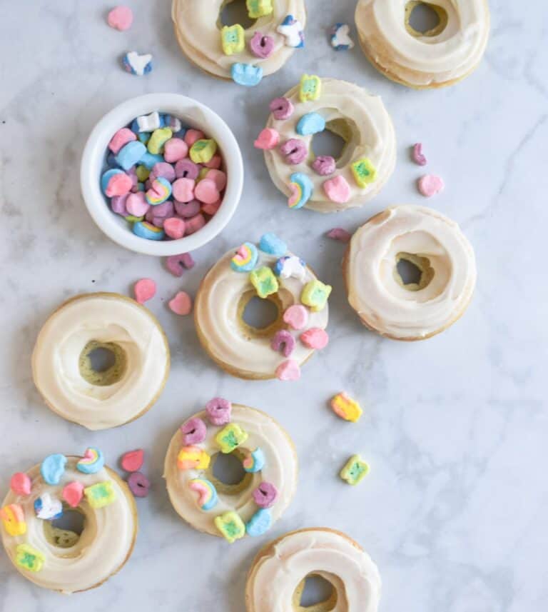 The doughnuts are spread out and a bowl of lucky charms is in the middle