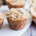 The sourdough banana muffin is on a white cutting board surrounded by other muffins.