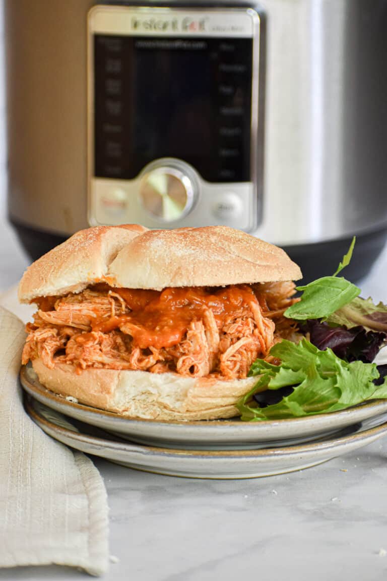 Pulled Chicken Sandwich in from of the Instant Pot with a salad on the side
