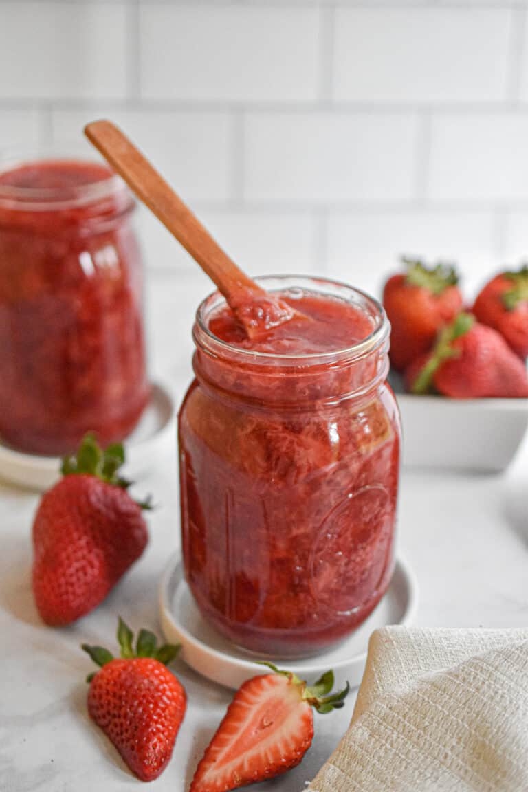 3 Ingredient Instant Pot Strawberry jam with a wooden spoon in the mason jar