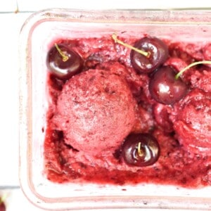A scoop of the cherry vanilla sorbet surrounded by cherries