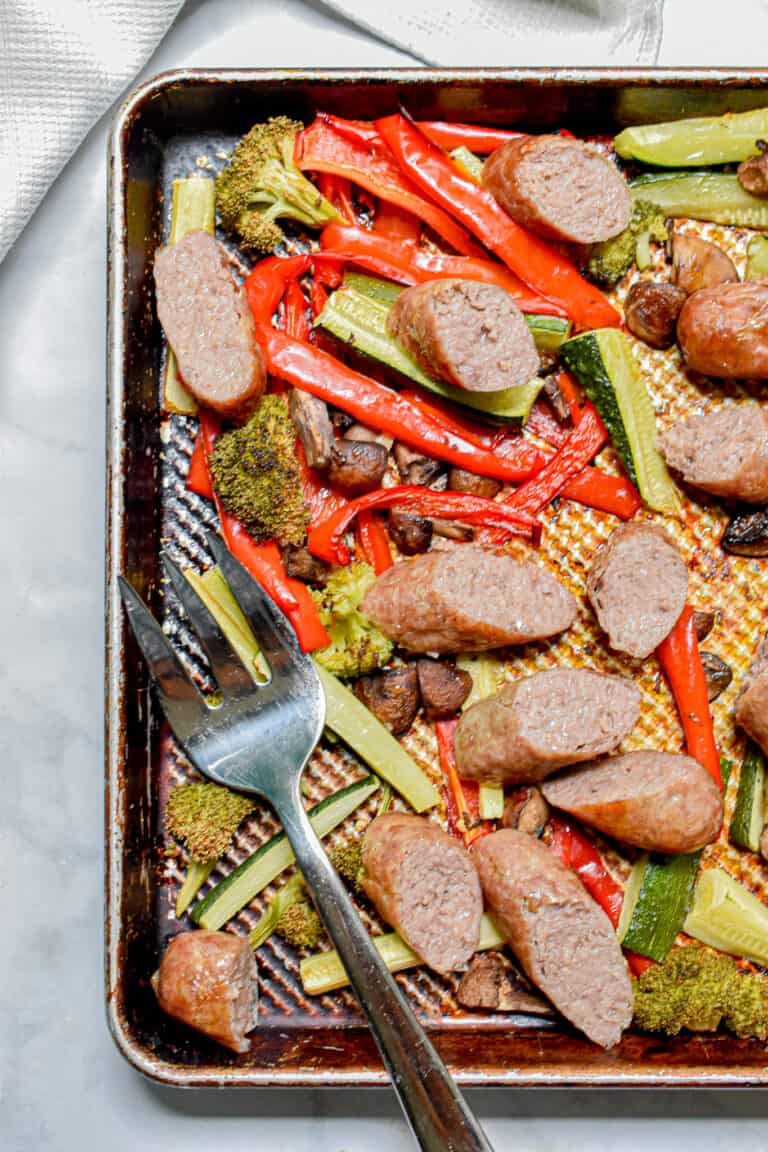 The sheet pan brats with roasted vegetables with a serving fork