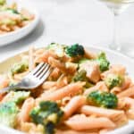 Some of the one pot chicken broccoli pasta is on a fork laying on the plate.