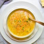An overhead view of the roasted broccoli and cauliflower soup with a spoon in the bowl