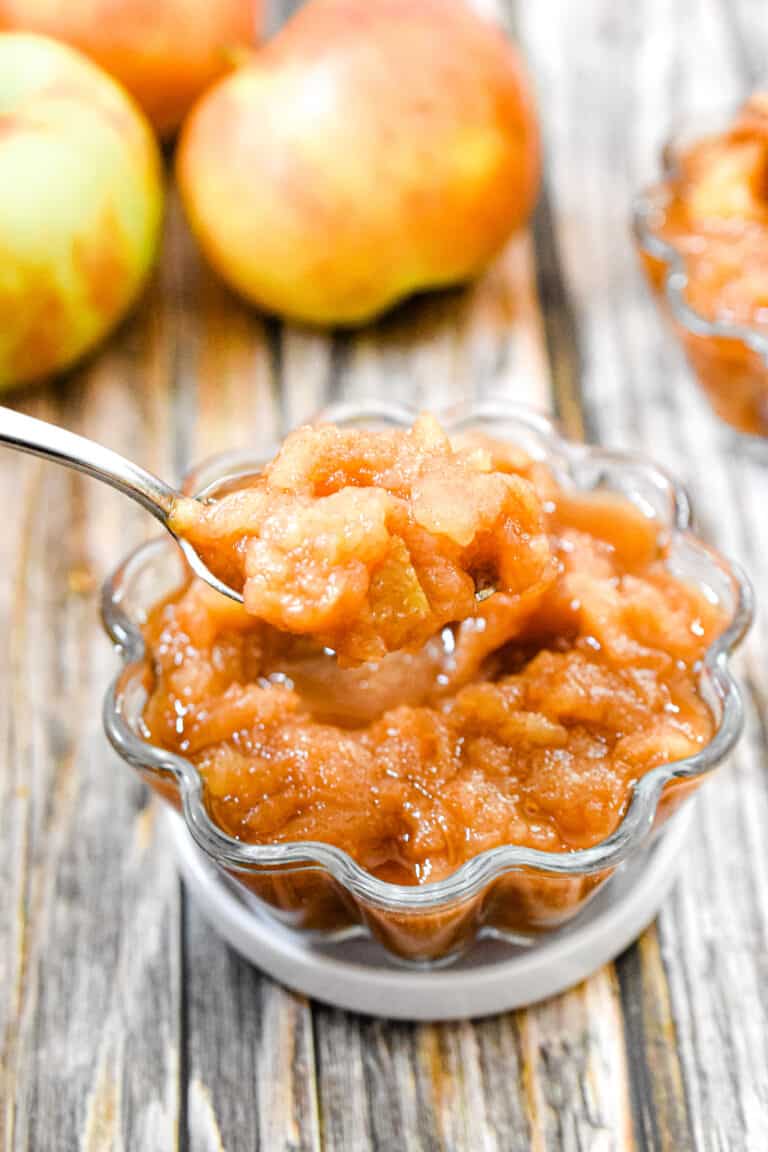 A spoonful of apple sauce is taken out of the bowl