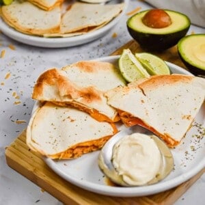 The quesadillas are served with avocado and sour cream