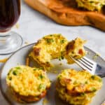 One jalapeno popper egg cup is cut open and the piece is placed on a spoon