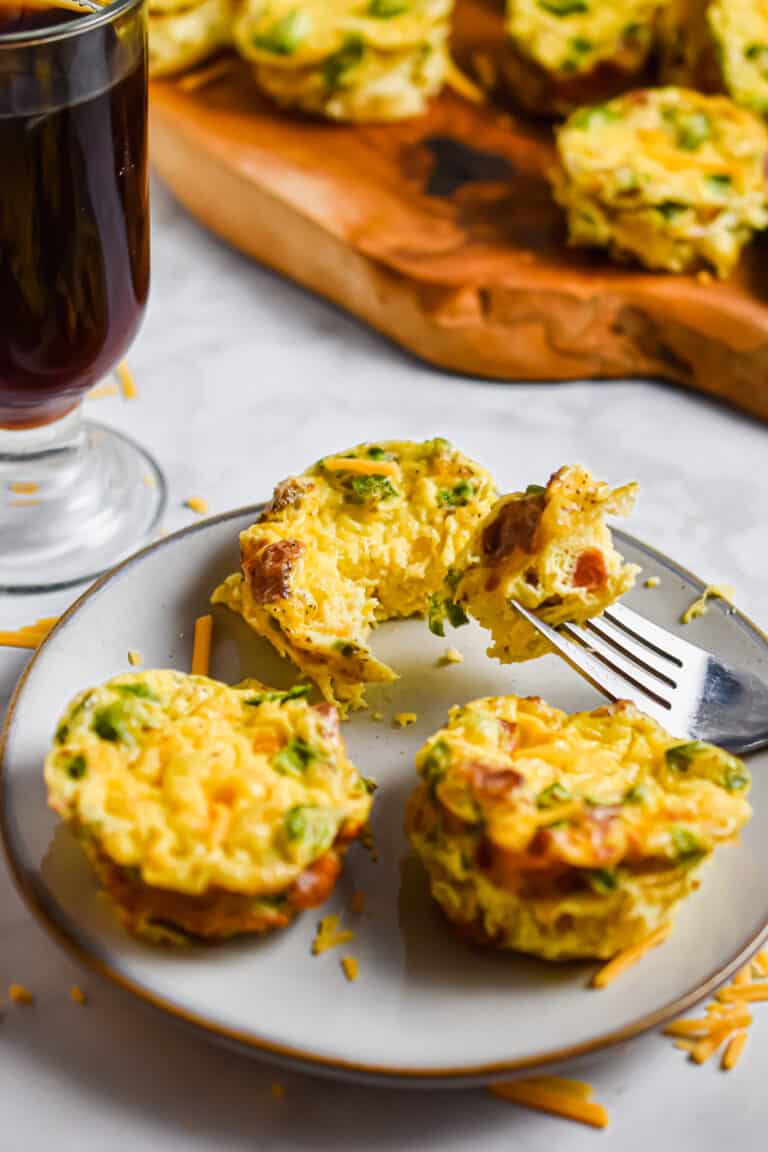 One jalapeno popper egg cup is cut open and the piece is placed on a spoon