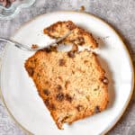 An overhead shot of a corner of the banana bread is removed with a fork