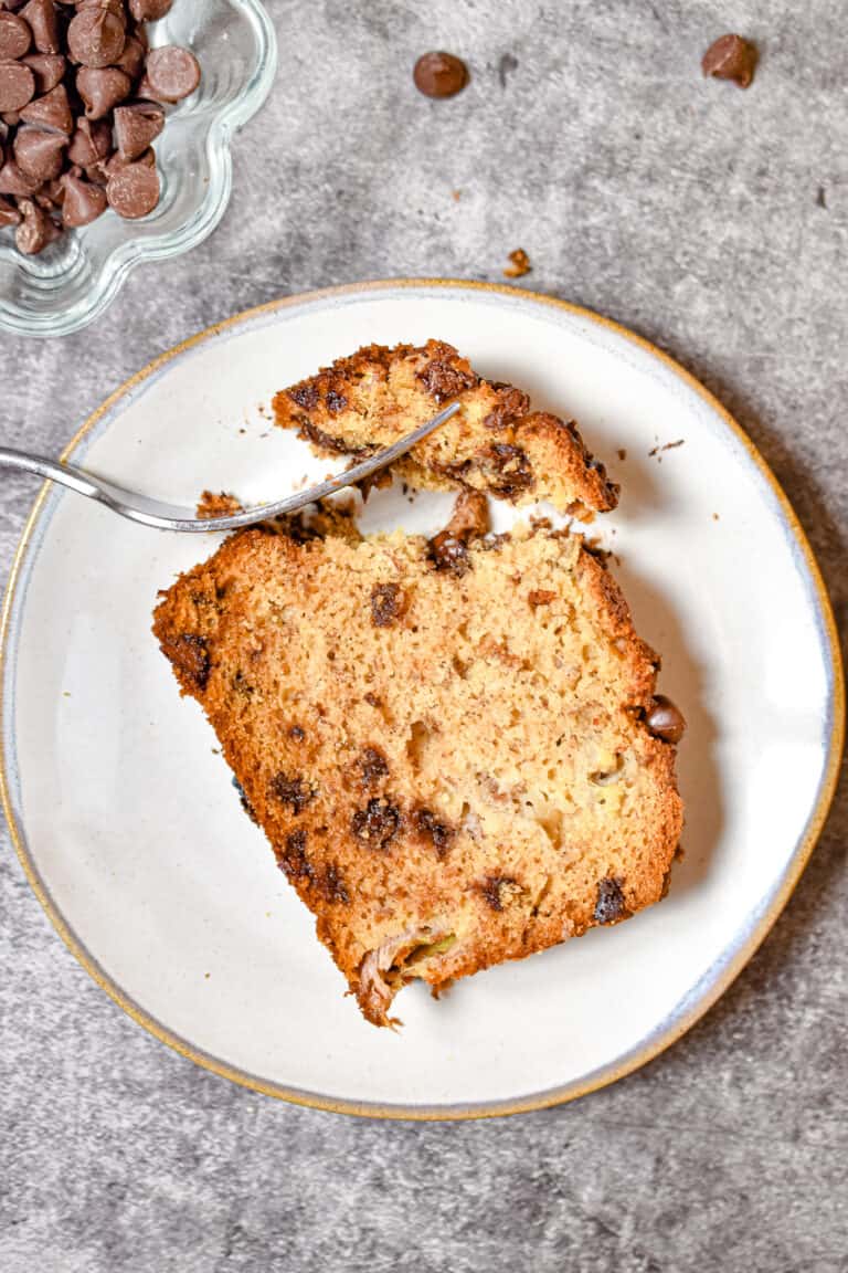 An overhead shot of a corner of the banana bread is removed with a fork