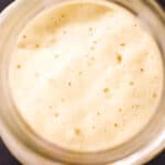 An overhead view of a freshly fed sourdough starter. It shows the correct way to keep a sourdough starter