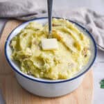 A spoon is in the middle of the bowl full of Instant pot mashed potatoes.