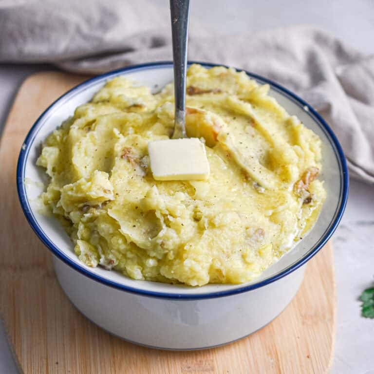 A spoon is in the middle of the bowl full of Instant pot mashed potatoes.