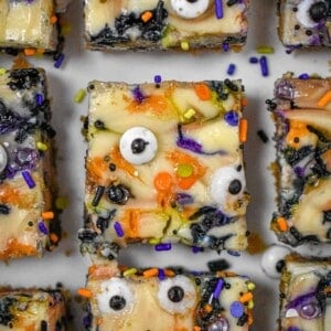 Nine Halloween Cheesecake Funfetti Bars are on a serving plate. This is a close up shot of them from above.