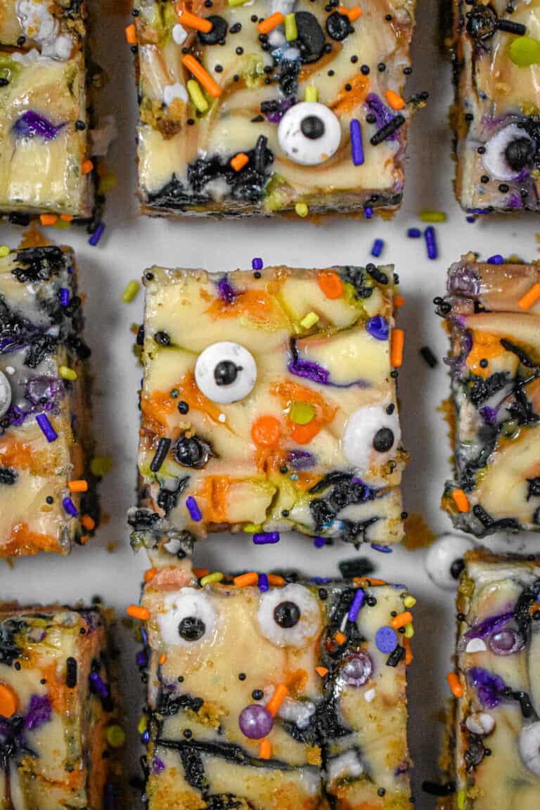 Nine Halloween Cheesecake Funfetti Bars are on a serving plate. This is a close up shot of them from above.