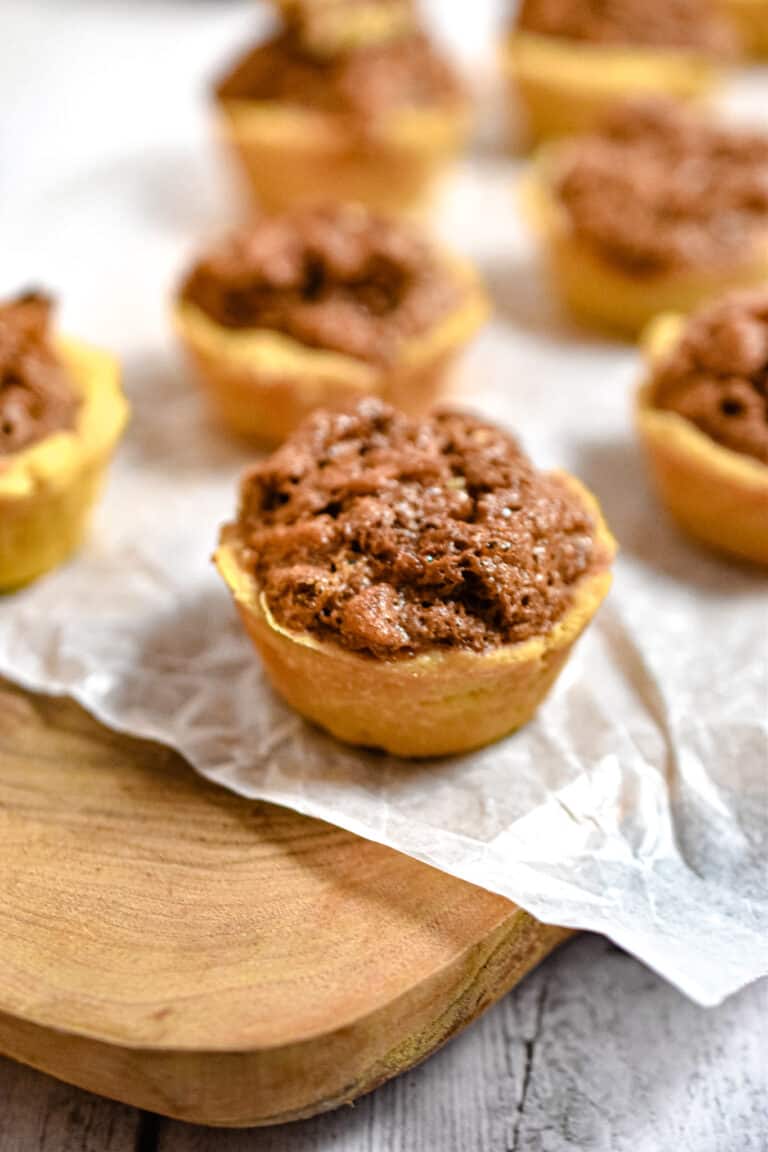 The mini walnut tarts are on a cutting board
