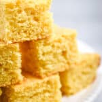 A close up of the kefir cornbread stacked on a cake plate.