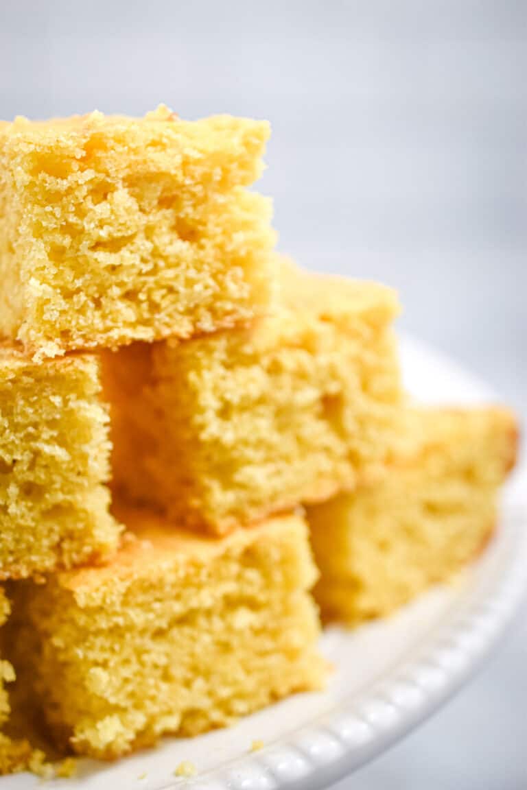 A close up of the kefir cornbread stacked on a cake plate.