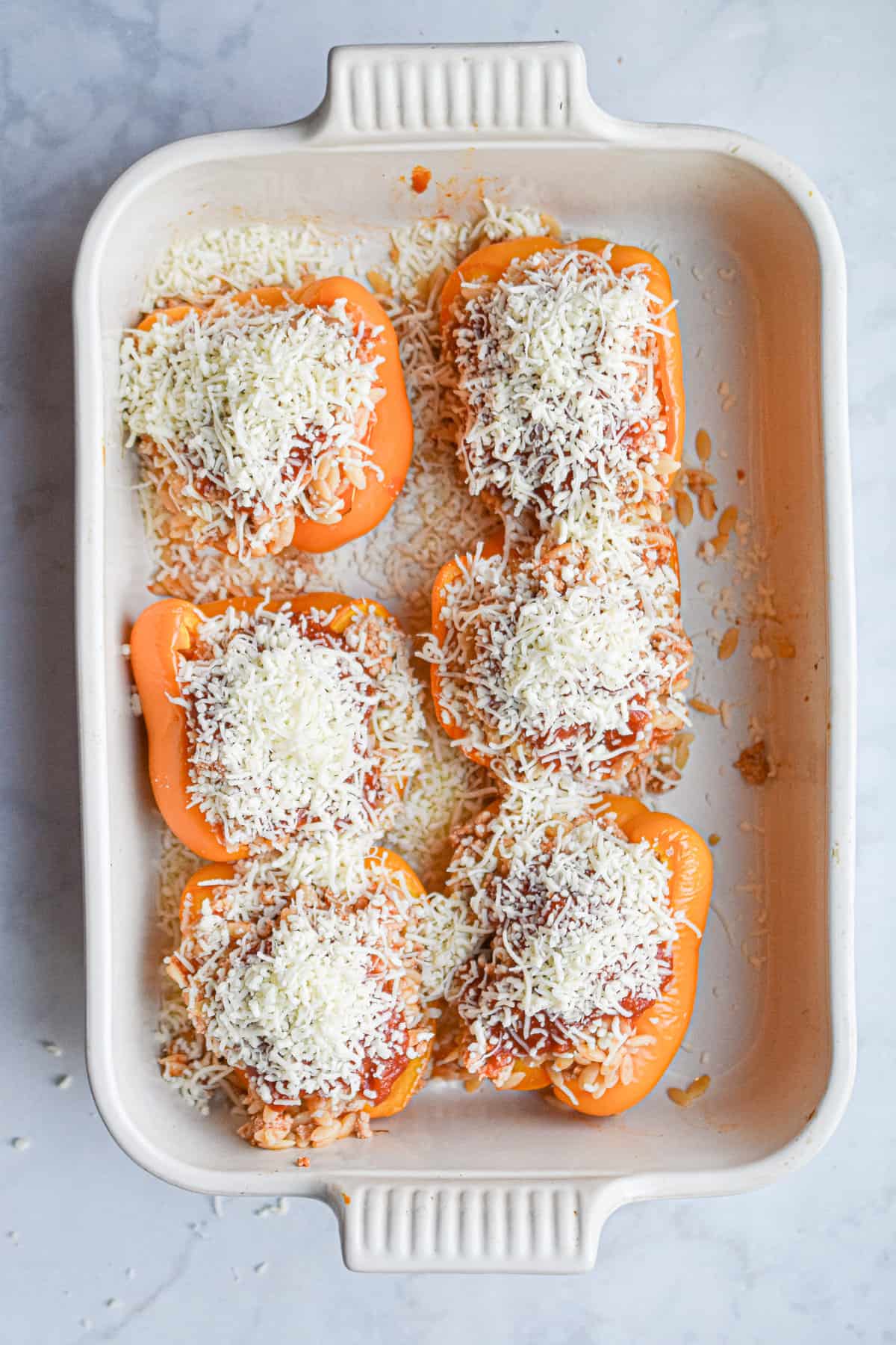 Mozzarella cheese is sprinkled on top of the peppers.