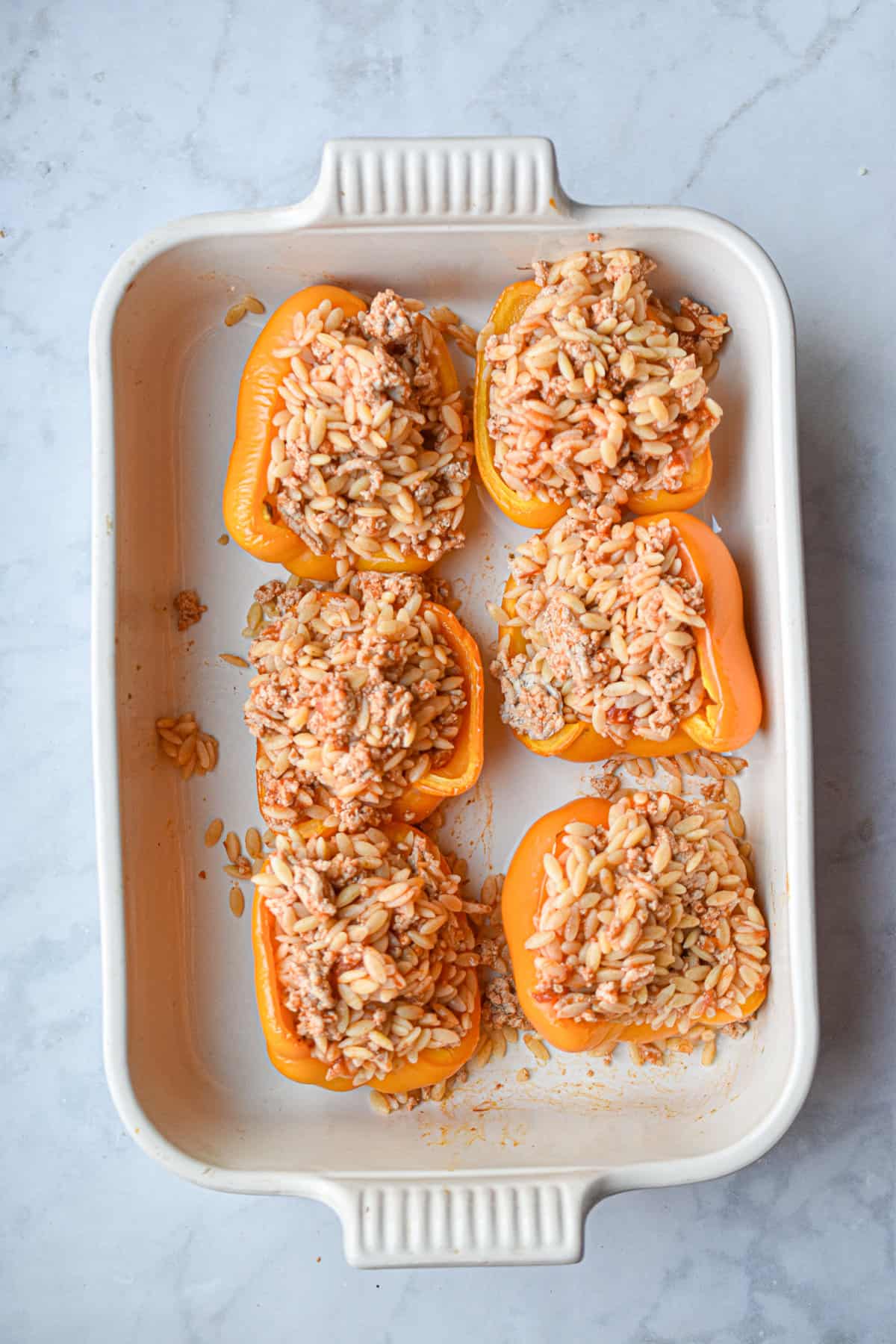 The orzo is stuffed into the peppers.