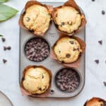 Two portions of the muffin tin are filled with chocolate chips and the other four sections are filled with thebaked muffins.