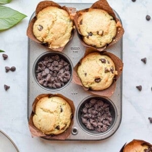 Two portions of the muffin tin are filled with chocolate chips and the other four sections are filled with thebaked muffins.