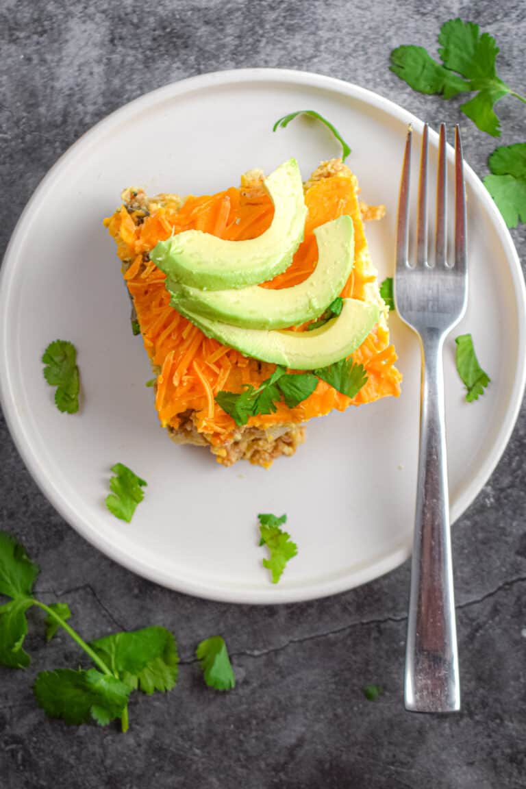 A piece of the vegan breakfast strata is topped with avocado