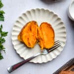 A potato is cut open on a plate.