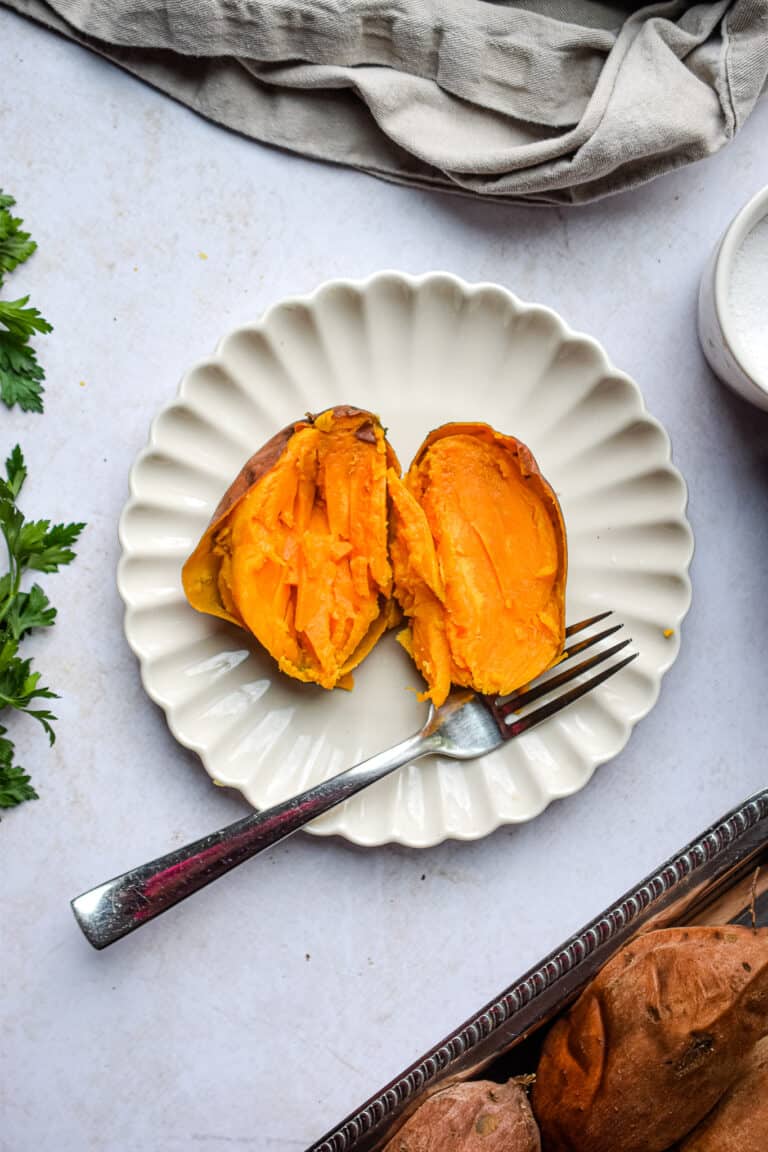 A potato is cut open on a plate.