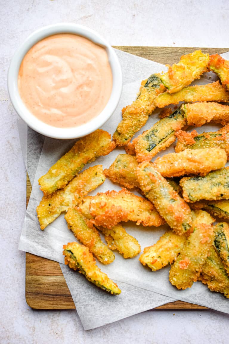 The zucchini fritte are on a cutting board with dipping sauce