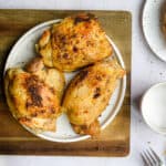 Three chicken thighs made in the instant pot are on a plate.