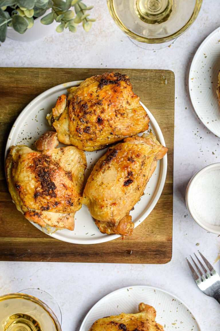 Three chicken thighs made in the instant pot are on a plate.