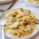 The chicken and mushrooms are surrounding by the spaghetti on a plate of Instant Pot Chicken Tetrazzini.