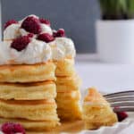 A fork is holding a piece of the stack of pancakes with self-rising flour.