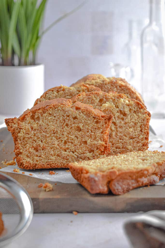 The banana bread with self rising flour is cut into slices and is on a cutting board.