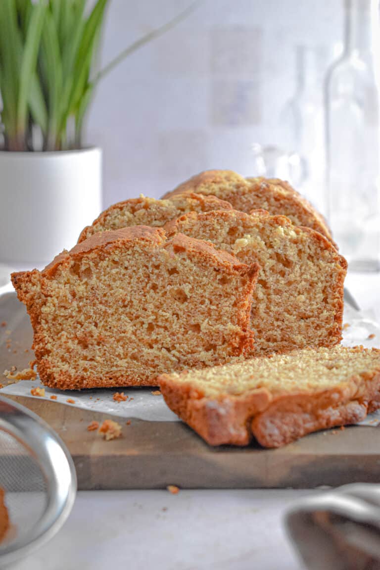 The banana bread with self rising flour is cut into slices and is on a cutting board.