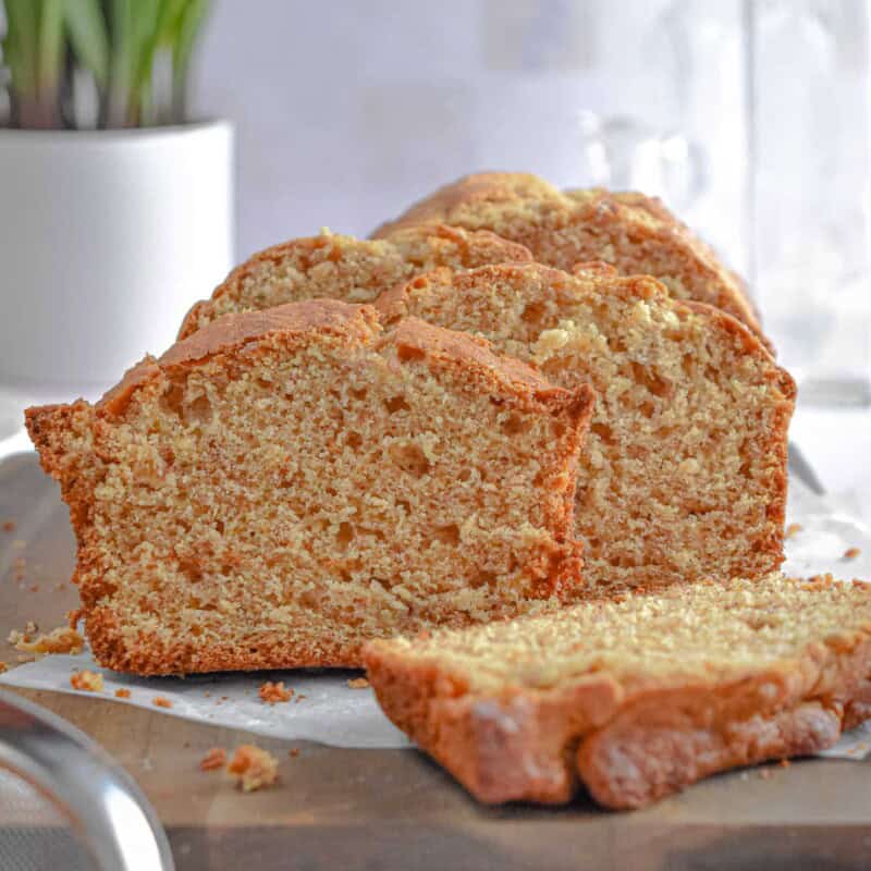 The banana bread with self rising flour is cut into slices and is on a cutting board.