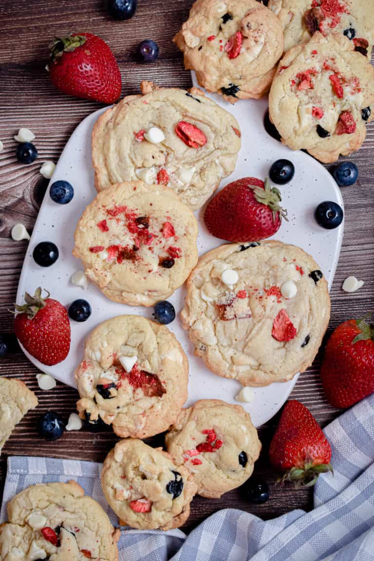 An overhead shot of red white and blue cookies on a cutting board
