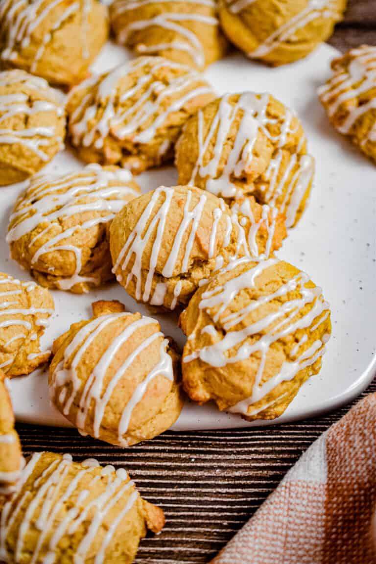 The sourdough pumpkin cookies are piled on a ceramic cutting board