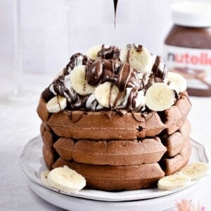 Nutella is being drizzled on the Nutella waffles.