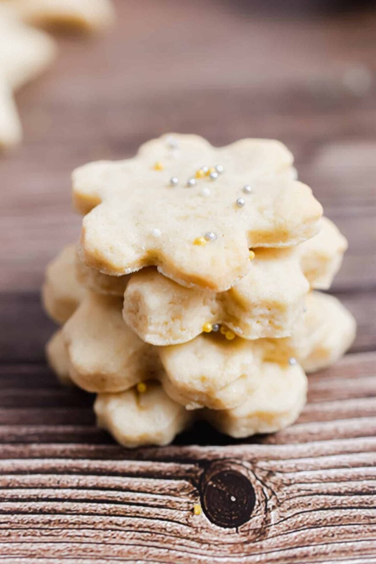 Sourdough Sugar cookie snowflake cookies are stacked on top of each other.