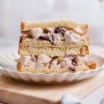 The cranberry walnut chicken salad is being served on bread that is cut in half.