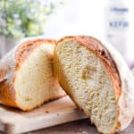 The bread is cut open with a bottle of kefir in the background.
