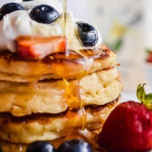 Maple syrup is being poured over the kefir pancakes.