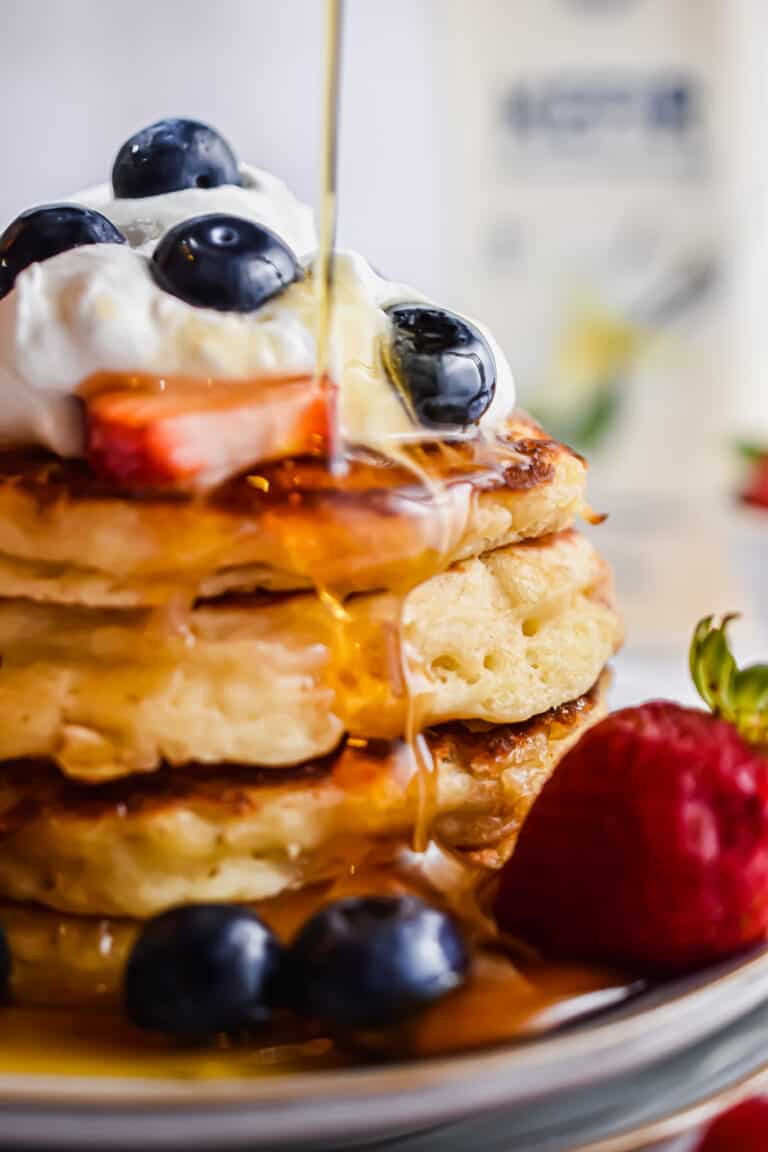 Maple syrup is being poured over the kefir pancakes.