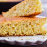 Two pieces of cornbread are on a fluted plate.