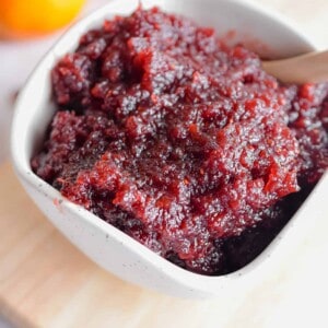 Clementines are in the background of the cranberry sauce.
