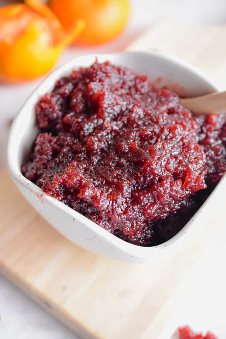 Clementines are in the background of the cranberry sauce.