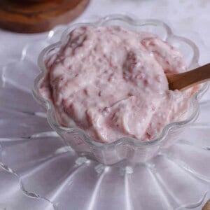 A bowl of cranberry mayonnaise with more cranberry sauce in the back.